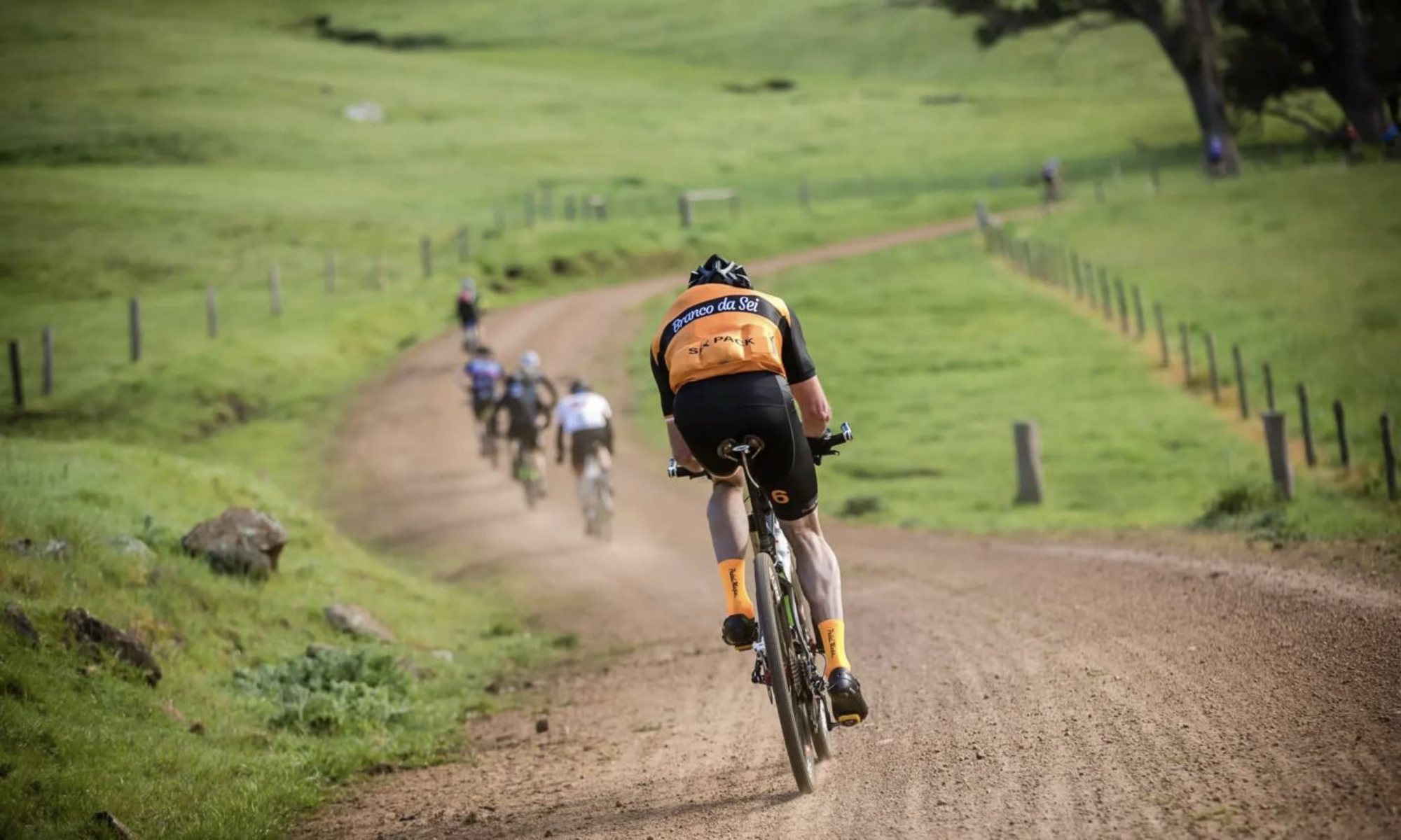 Riders on a dusty gravel road at speed